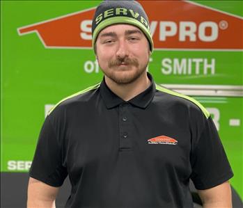 White male smiling in front of SERVPRO truck